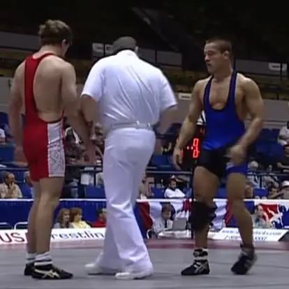 A match at the 1999 US World Team Trials: Jason Kraft and his opponent, one in red and one in blue, face the referee.