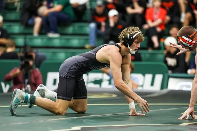 Alek VanBebber shoots in on the mat during a college match.