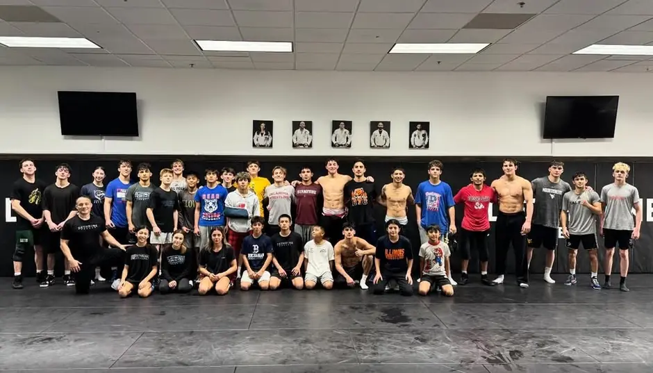 Dethrone’s college alumni and current wrestlers in rows on the Dethrone mats after the Christmas practice.