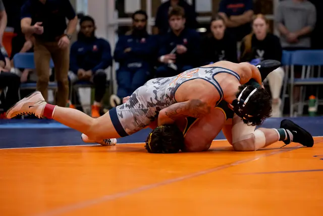 Rocco Contino works on top of an opponent on an orange mat.