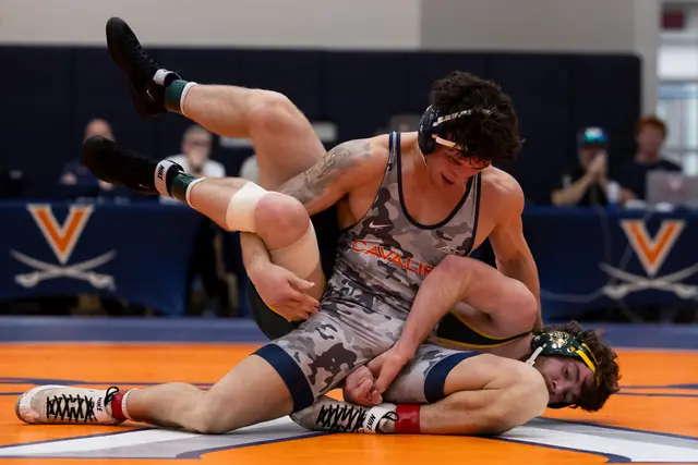Rocco Contino, in a camouflage singlet, scrambles with an opponent on the mat.