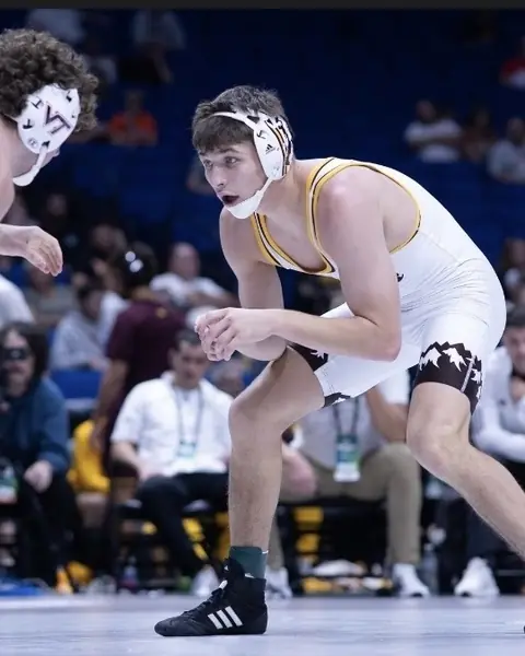 Sloan Swan, in a Wyoming singlet, squares up to an opponent during a college match.