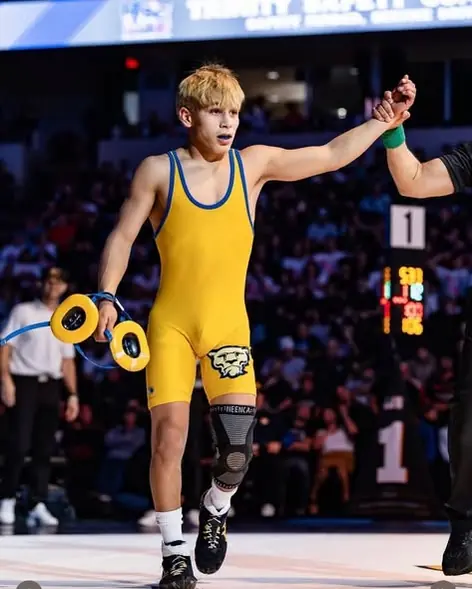A referee raises the hand of a Dethrone Wrestling Club wrestler at the 2026 California high school state tournament in Bakersfield.