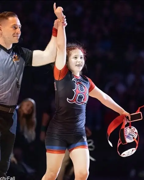 A referee raises the hand of a Dethrone Wrestling Club wrestler at the 2026 California high school state tournament in Bakersfield.